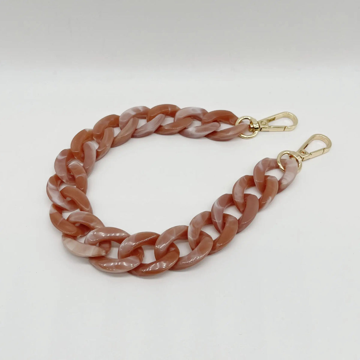 A close-up of a rose gold colored multicolor acrylic chain bracelet.