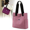 A pink nylon shoulder tote bag is shown being carried by a woman.