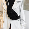 A woman wearing a white trench coat and black top, carrying a black nylon crossbody sling bag.