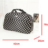 A black PU leather travel duffel bag with white polka dots shown from the top view.