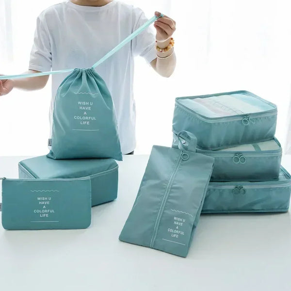 A person holds a teal fabric bag with a string, next to several matching portable storage organizer bags.