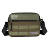 Olive green nylon shoulder bag with black straps and a beige fabric background