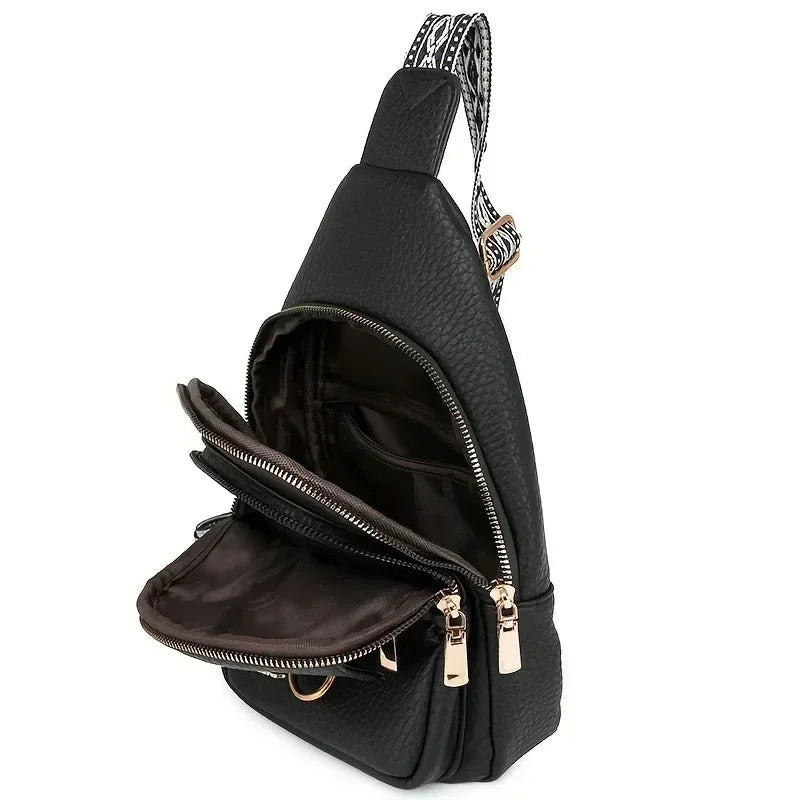 Schwarze Kunstleder-Crossbodytasche mit gemusterter, verstellbarer Trageleiste, von der Seite gezeigt.