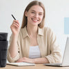 A smiling woman holds a black quilted tote bag next to a silver laptop on a wooden desk.