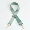 A light sage green adjustable nylon shoulder strap with a gold-toned buckle and metal hardware.