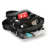 Black vintage leather messenger bag with a red and gold patterned pouch and a watch.