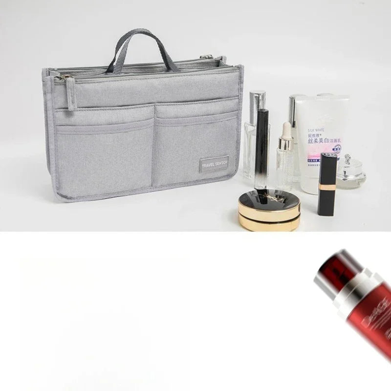 A gray fabric handbag with a handle is shown next to various cosmetic and beauty products.