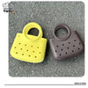 A yellow and brown round PVC handbag featuring a DIY hole design, shown on a gray textured surface.