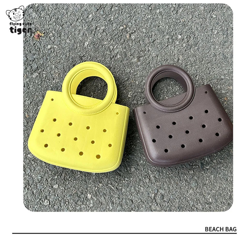 A yellow and brown round PVC handbag featuring a DIY hole design, shown on a gray textured surface.