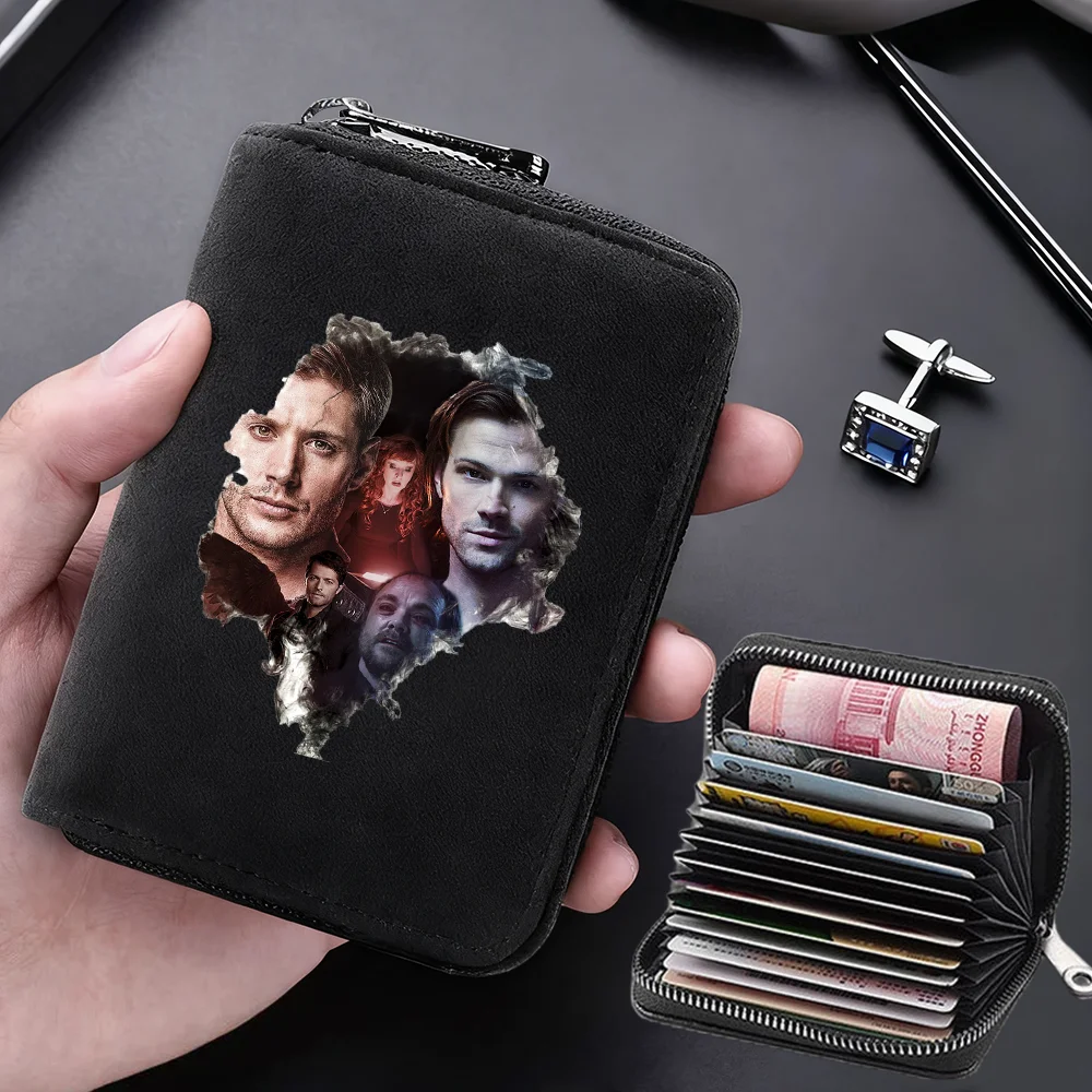 A black compact RFID-blocking card wallet with 11 slots is held in a hand, next to a small silver clip.