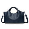 A dark navy blue luxury soft leather women's tote bag with a handle and shoulder strap.