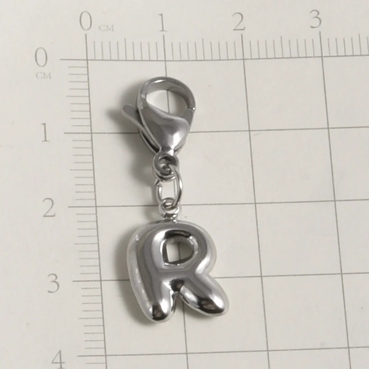 Silver stainless steel alphabet letter charm shaped like the letter R with a lobster clasp