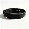 Un bracelet de silicone noir avec plusieurs trous et une petite ouverture circulaire, sur fond blanc.