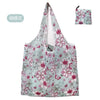 A reusable eco tote shopping bag with a light blue background and pink floral pattern.