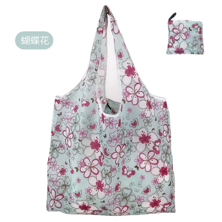 A reusable eco tote shopping bag with a light blue background and pink floral pattern.