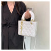 A woman holds a white diamond grid textured crossbody bag with gold hardware against a light background.
