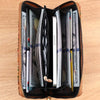 A brown leather wallet is open, displaying multiple stacks of cash and various cards inside.