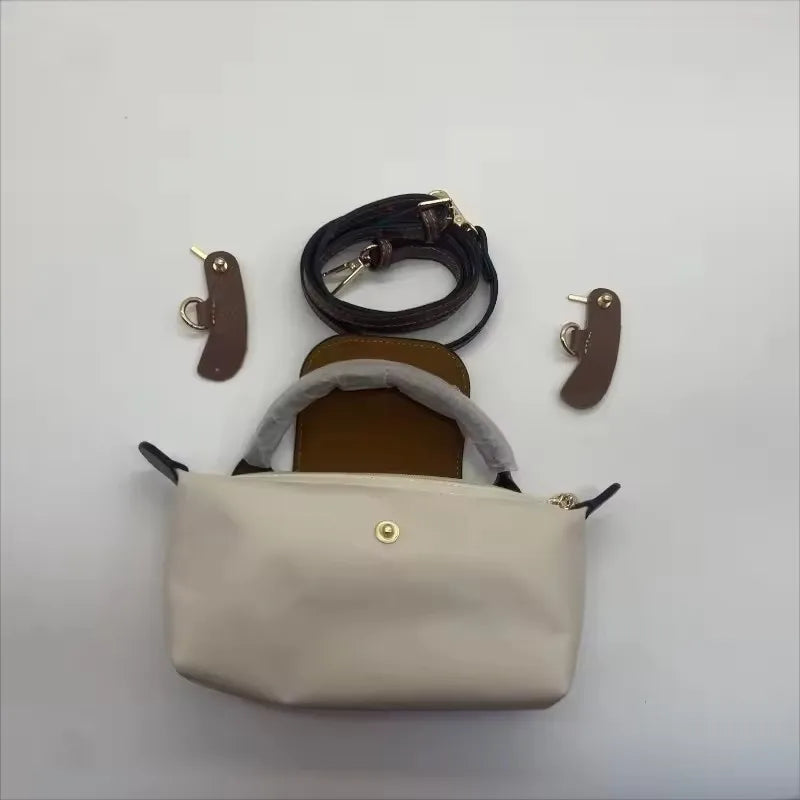 A beige waterproof nylon crossbody bag with a detachable mini pouch and black strap displayed on a white background.