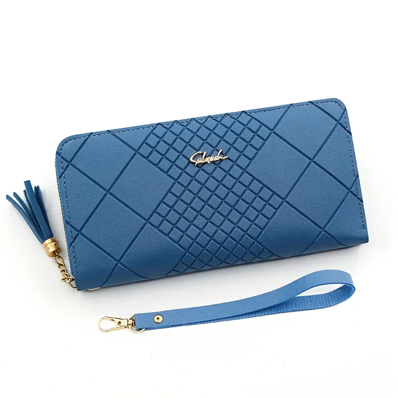 A navy blue quilted clutch wallet with gold hardware and a matching leather strap.