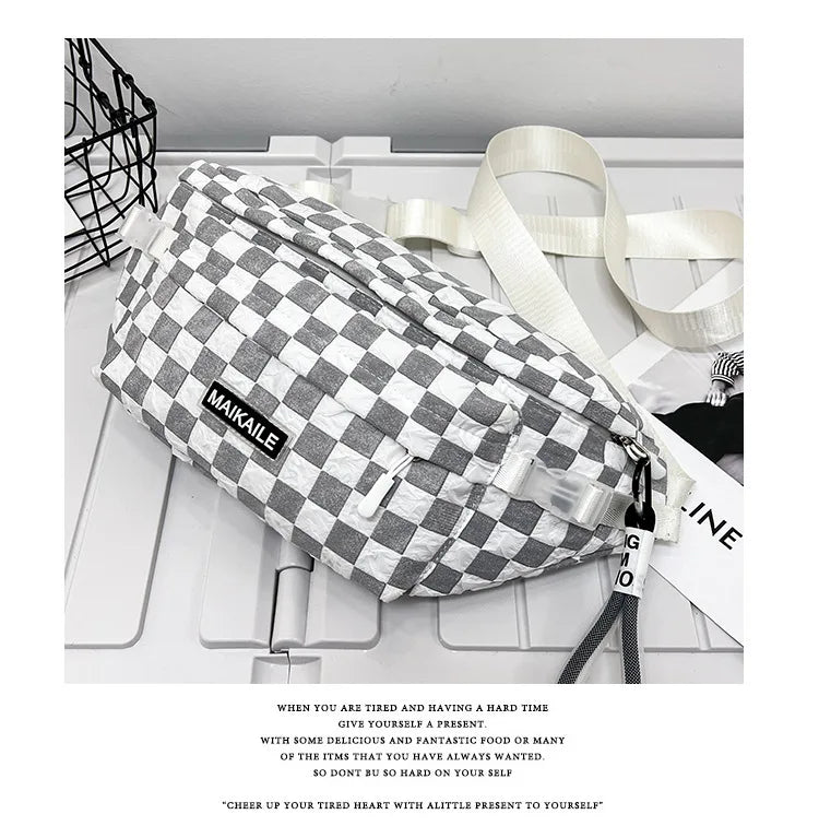 A plaid checkered crossbody chest bag in gray and white fabric with a light beige strap.