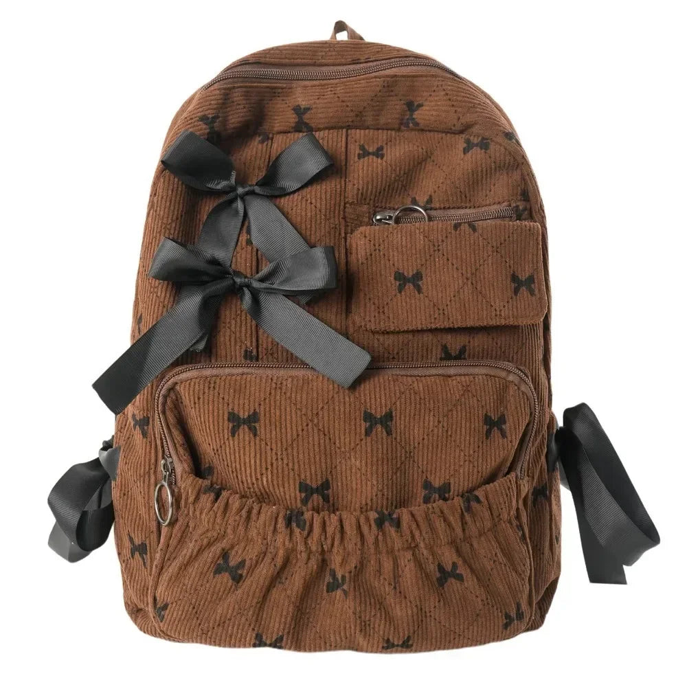 Brown corduroy backpack with a black bow print detail