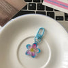 A small, translucent blue resin flower keychain resting on a white plate.