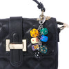 Black quilted purse with a gold clasp and a keychain charm featuring colorful dice.