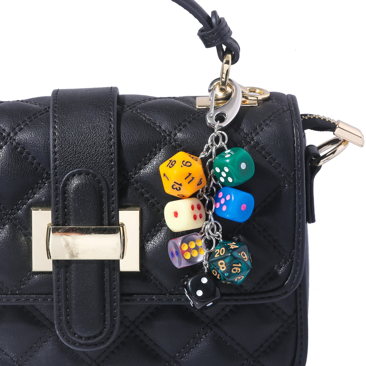 Black quilted purse with a gold clasp and a keychain charm featuring colorful dice.