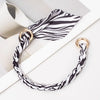 Schlagschleiftasche mit schwarz-weißem Zebra-Muster aus Seide und Kette vor weißem Hintergrund