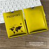 A yellow RFID metal passport holder with a world map design placed next to a laptop keyboard.