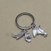 Silver keychain set featuring a cowboy boot, hat, and horseshoe charms.