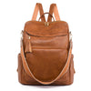A brown leather vintage tassel backpack with anti-theft features is shown from the back.