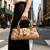 A woman holds a tan vegan leather tote bag with a gold lock buckle clip while walking on a city street.