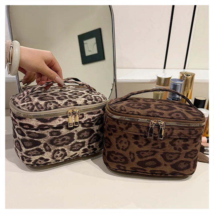 A brown faux suede cosmetic bag with a leopard print pattern is shown next to a mirror.