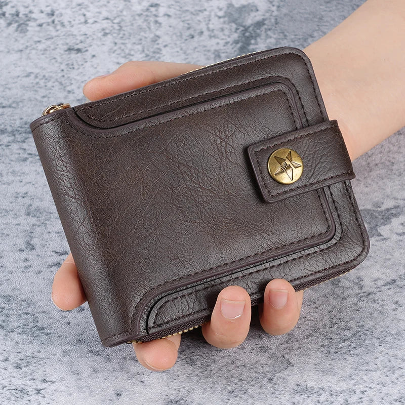 A dark brown leather card wallet with a horizontal zipper and brass accent is held in a hand.