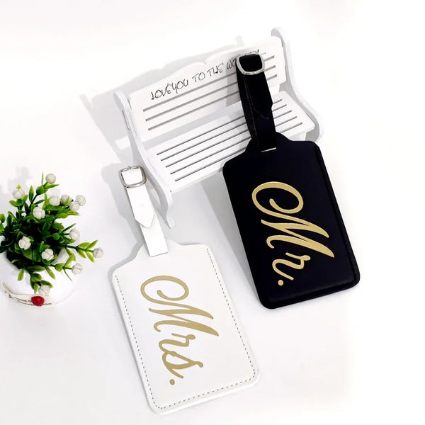 A set of personalized leather luggage tags featuring the initials Mr and Mrs with gold foil lettering.