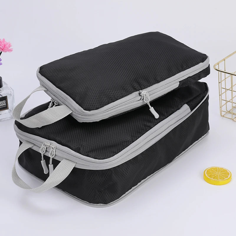 A stack of black and gray vertical travel organizer bags is shown on a white surface.