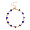 Gold charm bracelet featuring blue evil eye charms on an adjustable chain.