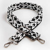 A black and white jacquard patterned strap for an adjustable wide crossbody bag.