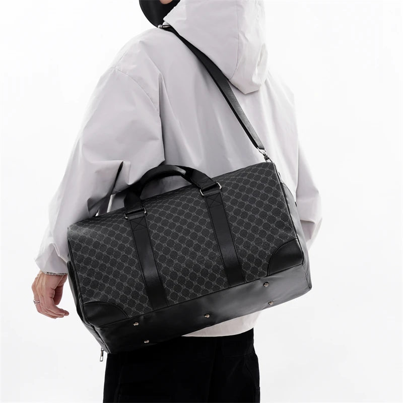 A person wearing a white hooded jacket is holding a black leather-trimmed travel duffle bag.