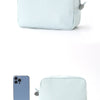 A light blue and white striped cosmetic bag with a zipper closure shown next to a smartphone.