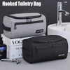 A gray hooked toiletry bag is shown next to a black light travel toiletry bag and a modern bathroom sink.