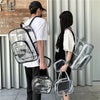 A person is holding a clear waterproof transparent backpack in front of a light gray wall.