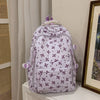 Mochila de varios bolsillos con estampado floral lila claro sobre una superficie blanca.
