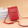 A red vintage PU leather crossbody bag with an adjustable strap resting on a light beige surface.