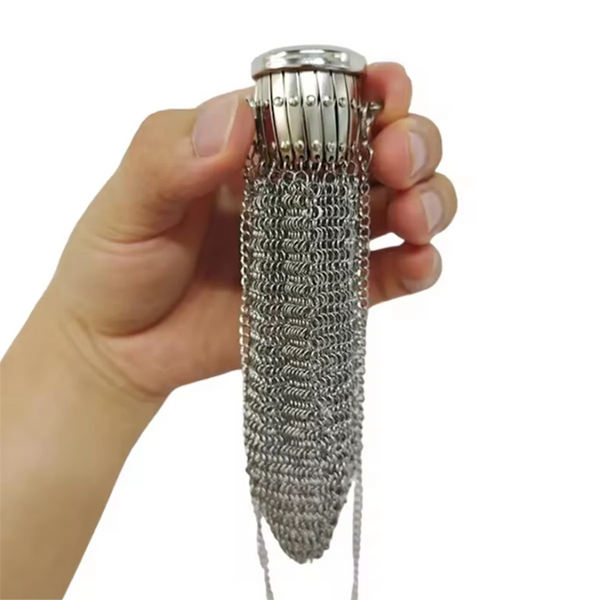 A hand holds a silver vintage coin purse with a textured chain and a metal cap.