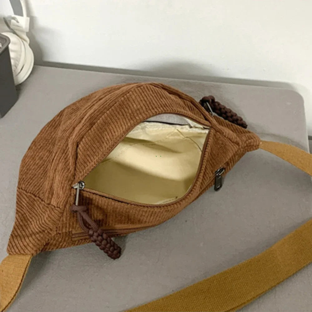 A brown corduroy waist pack for women is shown open, displaying the interior lining and attached leather straps.