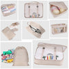 A set of seven folding travel organizer bags in beige and pink fabric for storing toiletries and personal items.