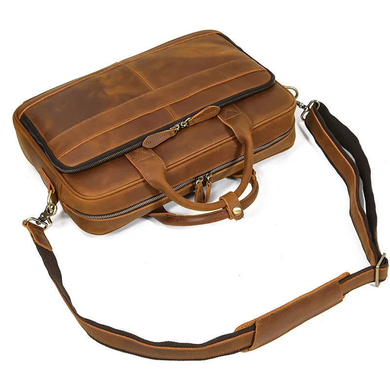 A brown vintage genuine leather briefcase with a flap and leather strap is shown.