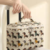 A quilted cosmetic travel bag featuring a dachshund print is being held by a person's hand.